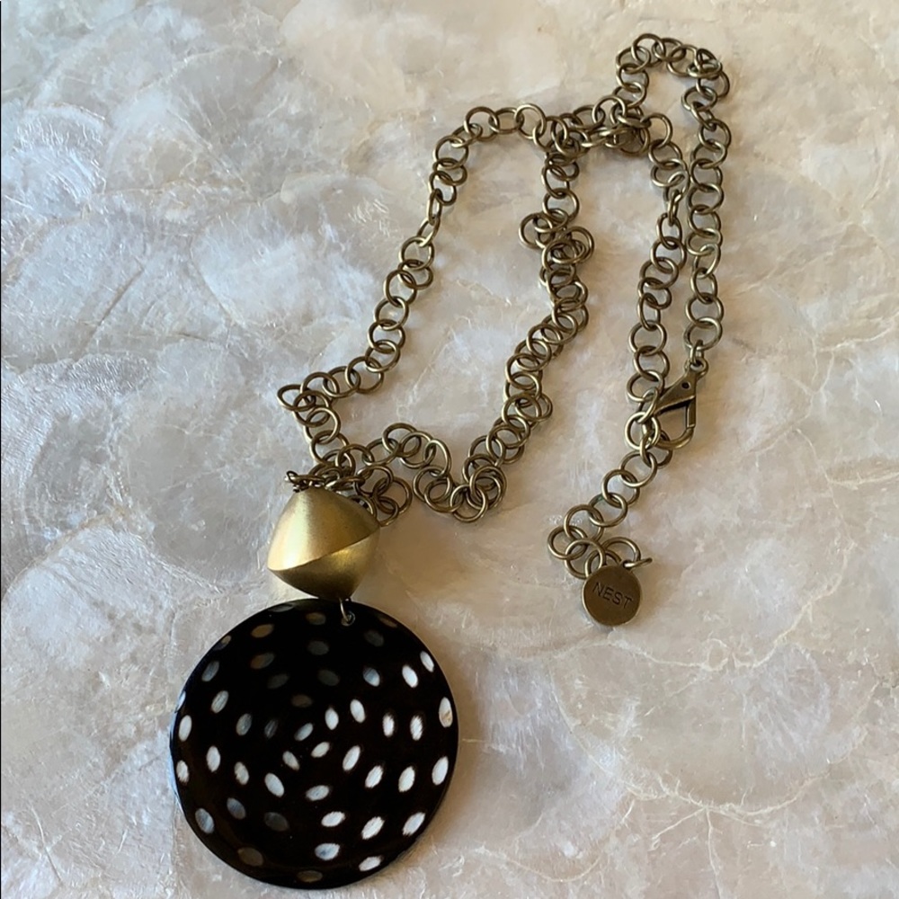 NEST Bow necklace. Metal has a brassy finish.